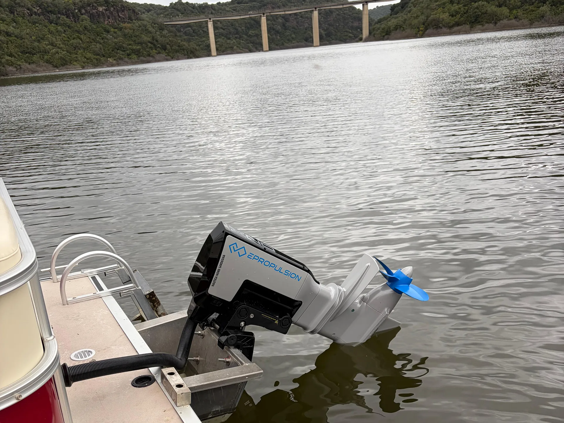 Il fuoribordo Epropulsion da 20 kW con sullo sfondo il ponte sul lago Cedrino