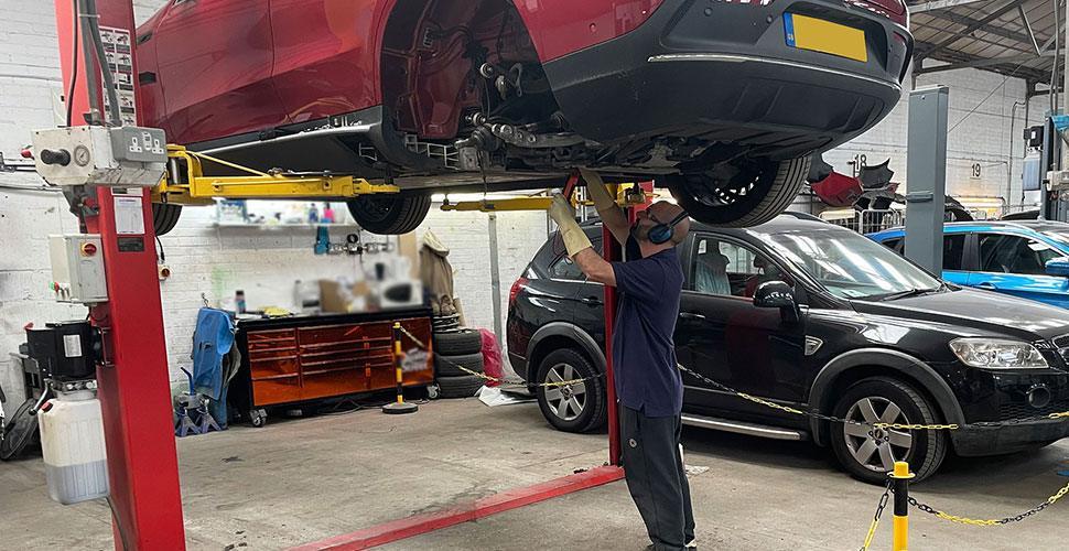 Un meccanico al lavoro su un'auto elettrica auto elettriche incidentate