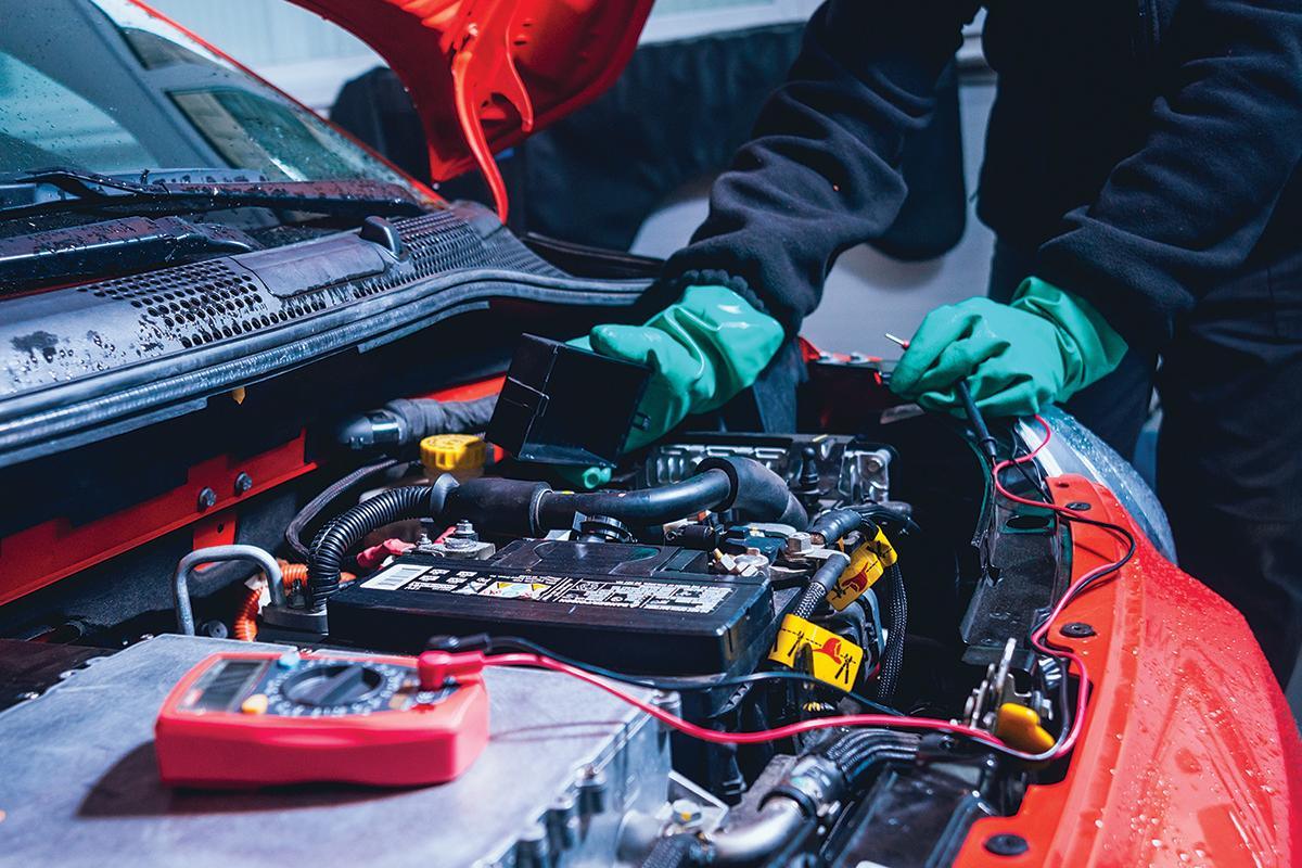 auto elettrica in riparazione Un meccanico al lavoro su un'auto elettrica