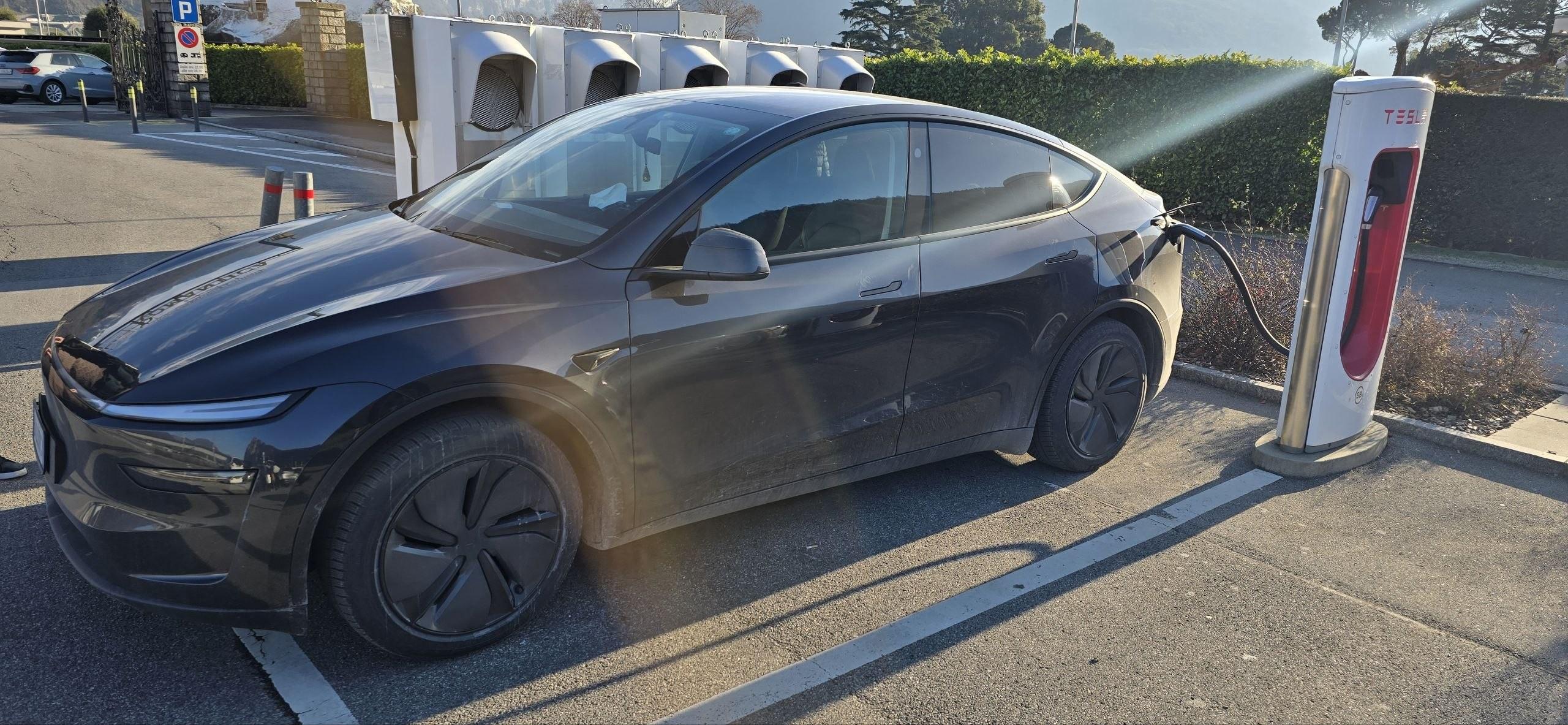 Tesla Model Y in ricarica presso un Supercharger Tesla Model Y
